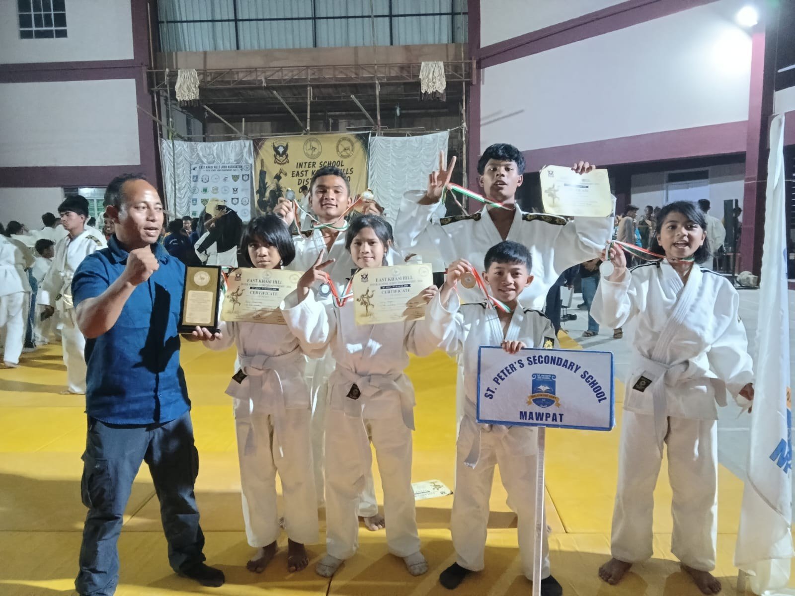 Martial arts and judo champions with trophies and certificates